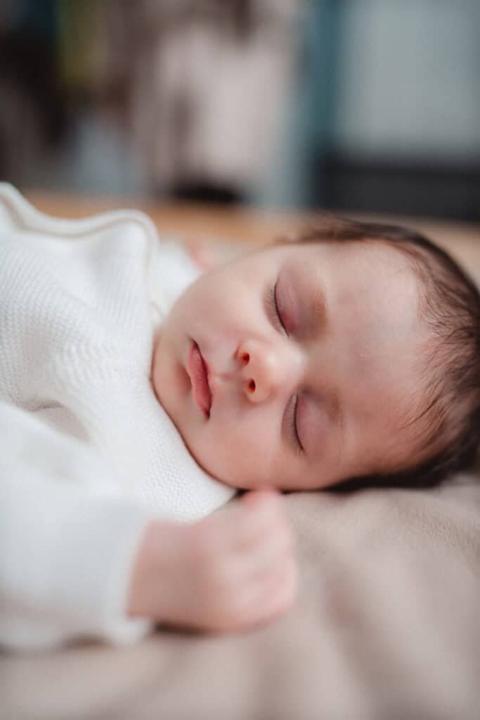 A 14-day-old baby girl sleeps peacefully on her side in a lifestyle photo taken in Kitsilano.