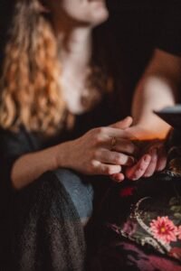 A couple shares a tender moment as they discuss their love story next to a stack of board games, captured in a cozy living room setting by Zur Photography.